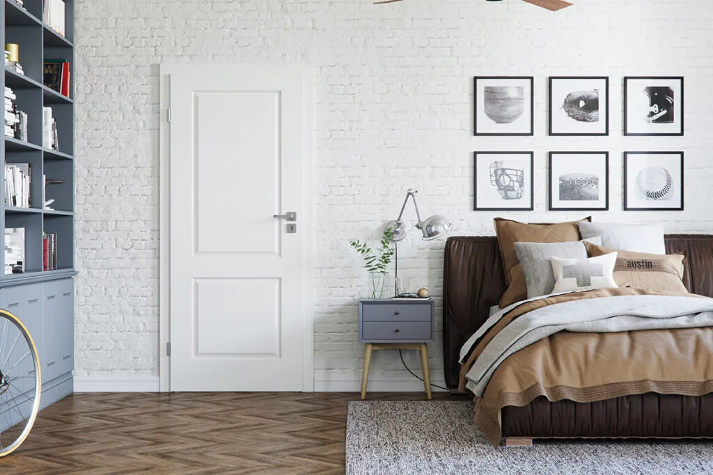 Elegant white interior door with a luxury designer handle in a modern bedroom, featuring a stylish blend of contemporary decor, textured brick walls, and cozy furnishings, enhancing the room's sophisticated aesthetic.