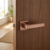 Raflesia on Square Rosette high-end square door handles featuring a rich PVD copper finish with elegant linear detailing on a natural timber door.