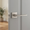 Elegant satin nickel Salvia on Square Rosette timeless square door handles with a soft metallic glow, mounted on a neutral light grey door.