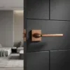 Setia on Square Rosette classic square internal door handles in a unique PVD copper finish, providing a warm metallic accent on a modern black door.