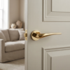 Dalia on Round Rosette in polished gold, offering a high-shine statement look for designer internal door handles on a neutral interior door.