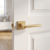 Erba on Square Rosette in a matt gold finish, stylish modern square internal door handles fitted to a white interior door.