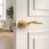 Matt gold Gerbera on Round Rosette, a pair of timeless internal door handles shown on a classic white door in a bright modern interior.