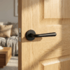 Matt black Irga on Round Rosette, premium round internal door handle on a natural oak interior door.