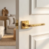 Luxury square internal door handles in polished gold finish, featuring the Ismena lever on a square rosette for a refined, high-end interior style.