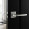Luxury square internal door handles in satin chrome finish, featuring the Ismena lever on a square rosette fitted to a dark painted internal door.