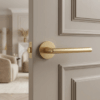 Matt gold Kalmia on Round Rosette installed on a taupe panelled door, showcasing the sleek round internal door handle design in an elegant living space.