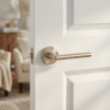 Satin nickel Kalmia on Round Rosette displayed on a white panelled door, showcasing the sleek round internal door handle design in a soft modern interior.