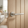 Designer round internal door handles – Lavanda on Round Rosette in sleek satin nickel displayed on a pale timber internal door.