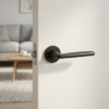 Luna on Round Rosette in matt black, showcasing contemporary round internal door handles on a modern white door.