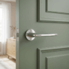 Luna on Round Rosette in polished chrome, a sleek example of contemporary round internal door handles on a green panelled door.