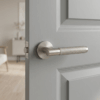 Molinia on Round Rosette satin nickel handle displayed on a soft grey door, highlighting understated round door handles for modern interiors.