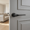 Matt black Orchide on Round Rosette, showcasing elegant curved door handles on a grey internal door.