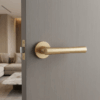 Papavera on Round Rosette in matt gold, a classic round door handle fitted to a grey internal door.