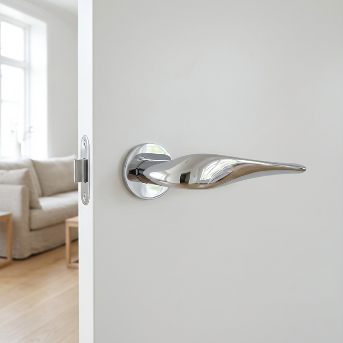 Petunia - Polished Chrome Petunia on Round Rosette in polished chrome, showcasing sculpted round door handles on a white interior door.