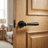 Rosemary on Round Rosette in matt black, featuring classic round internal door handles on a traditional oak door.