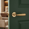 Modern round internal door handle in PVD gold, Utrica on Round Rosette fitted to a green interior door.