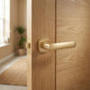 Stella on Rounded Square Rosette in matt gold, featuring modern round square door handles on a light oak interior door.