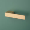 Ludisia on Hidden Rosette – modern frameless door handle for internal doors in matt gold finish on green background.